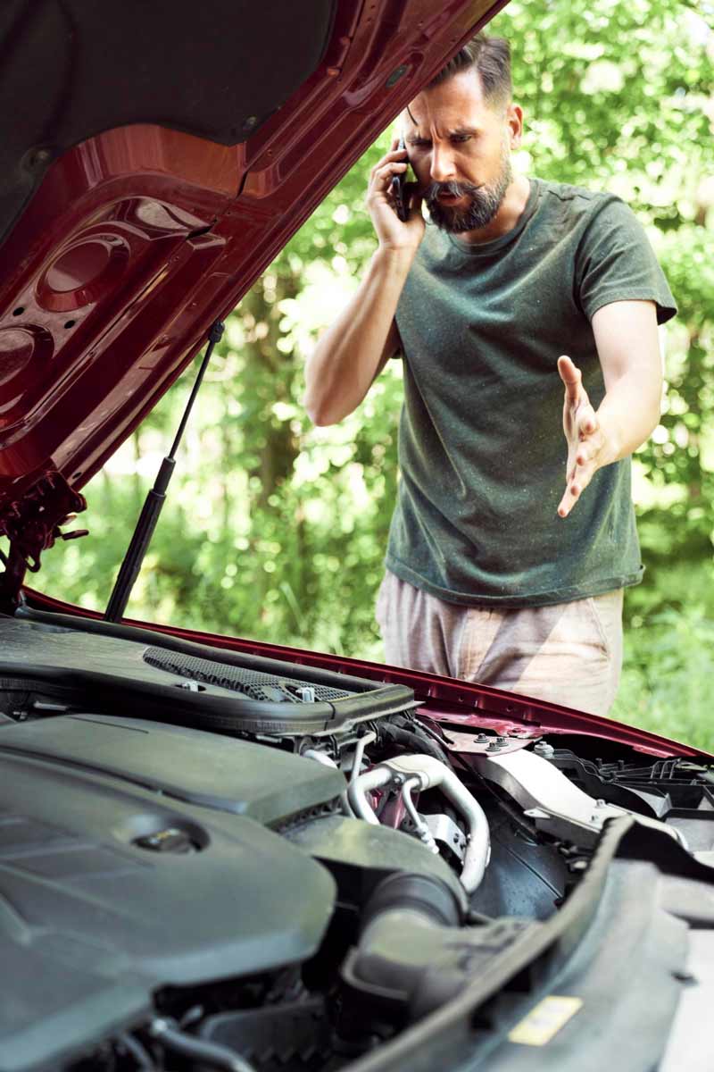 Junger Mann prüft Getriebeschaden bei Schrottauto Ankauf Raesfeld
